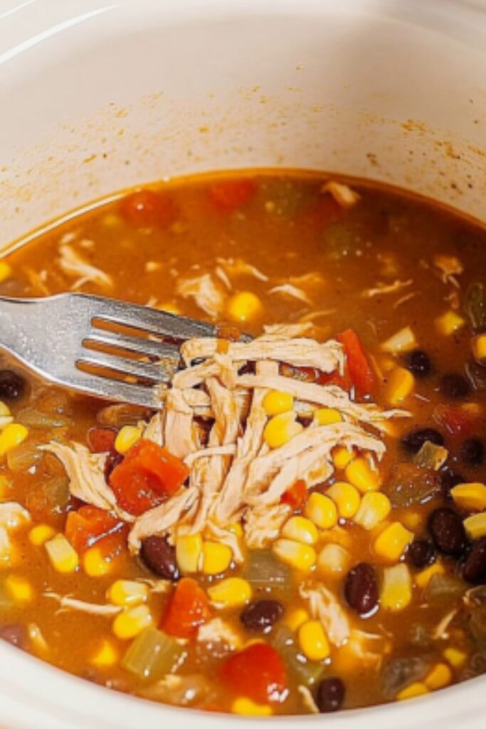 Using two forks, shred the chicken breasts directly in the slow cooker