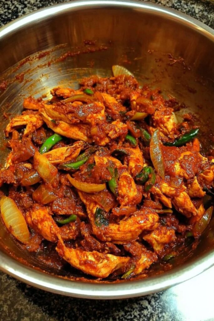 Shredded chicken mixed with rich spices, onions, and green chilies for making Chicken Choila