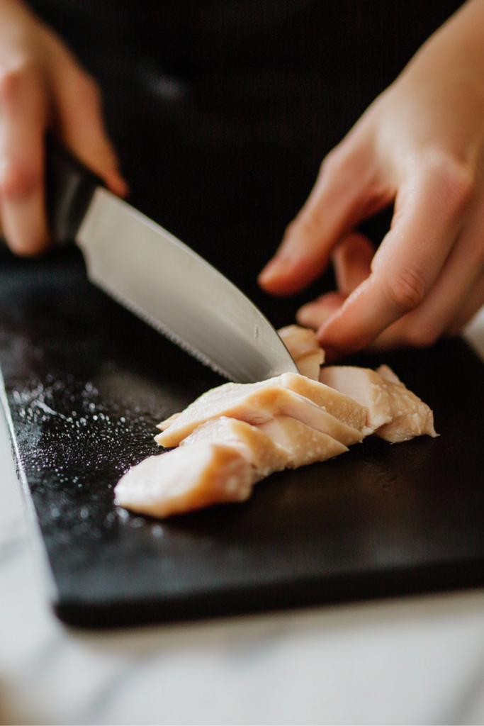 Hand slicing cooked chicken breast
