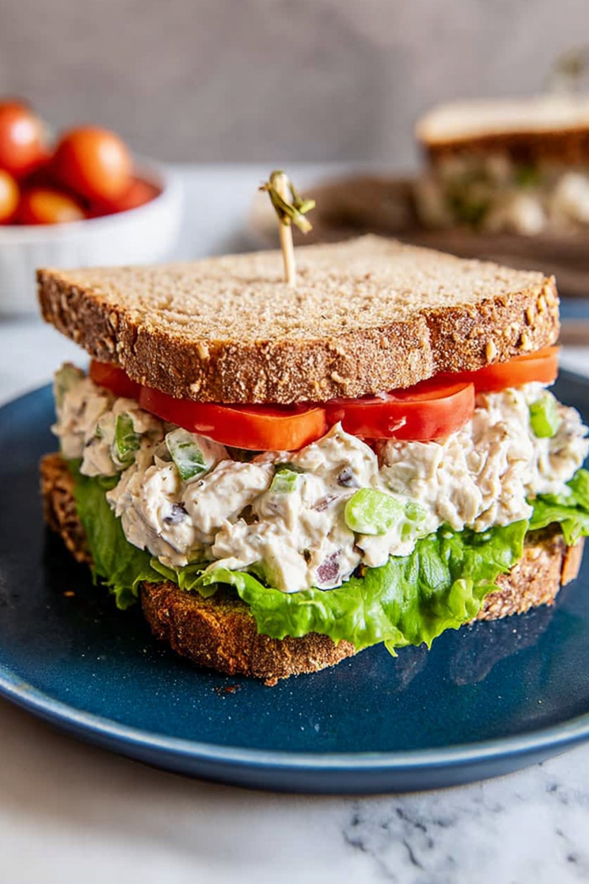 Traditional chicken salad sandwich on whole-grain bread with lettuce and tomato.